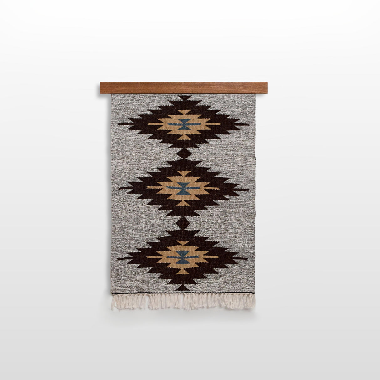 The Smilyv (Bold) Wool Rug / Wall Hanging features geometric patterns in brown, black, beige, and blue on a wooden rod, adding modern neutral charm to your décor as both a wall hanging and a rug.