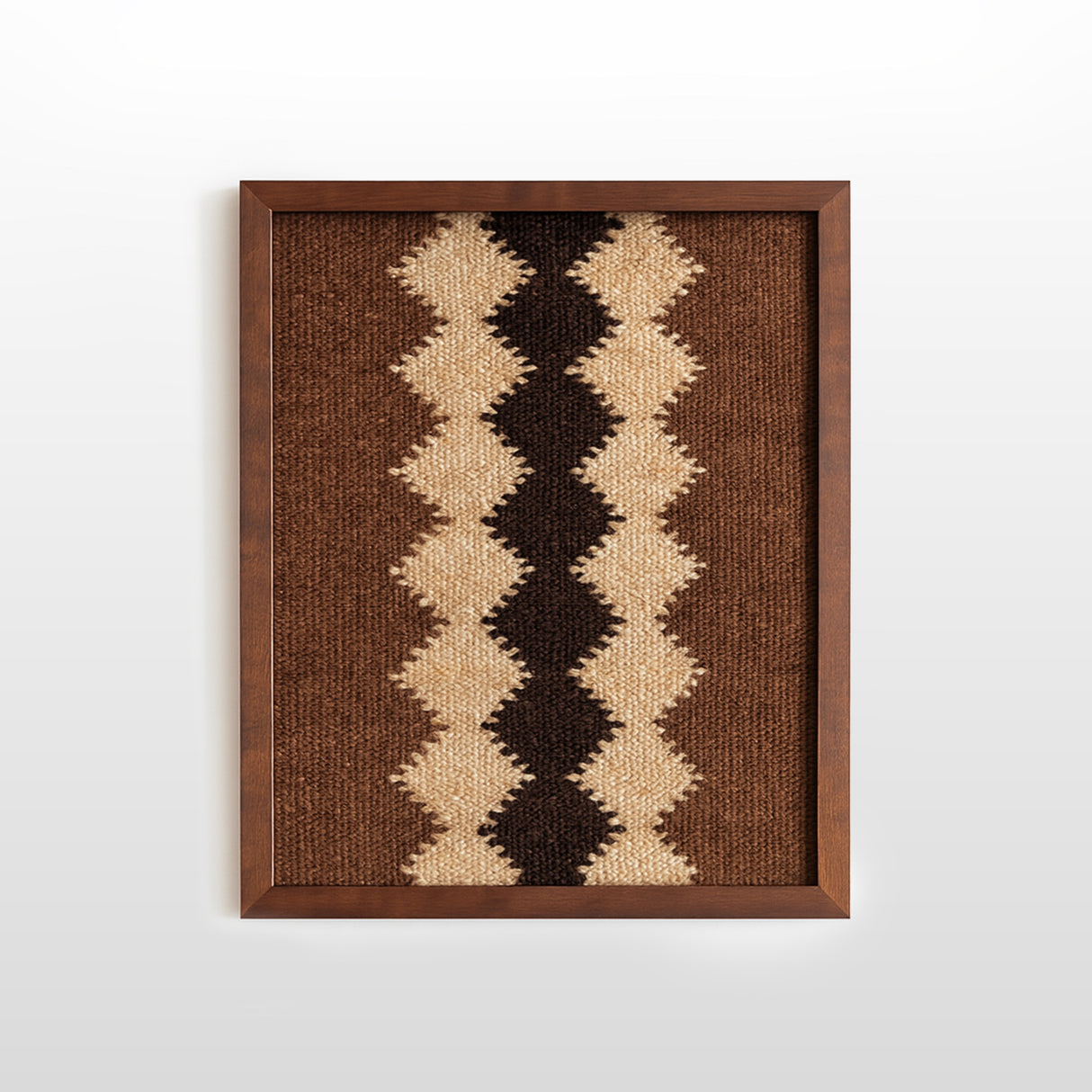 The Dobre (Good) Wool Framed Wall Art features a geometric zigzag pattern in brown, beige, and black on white—an artisanal woven textile perfect for elevating your decor.