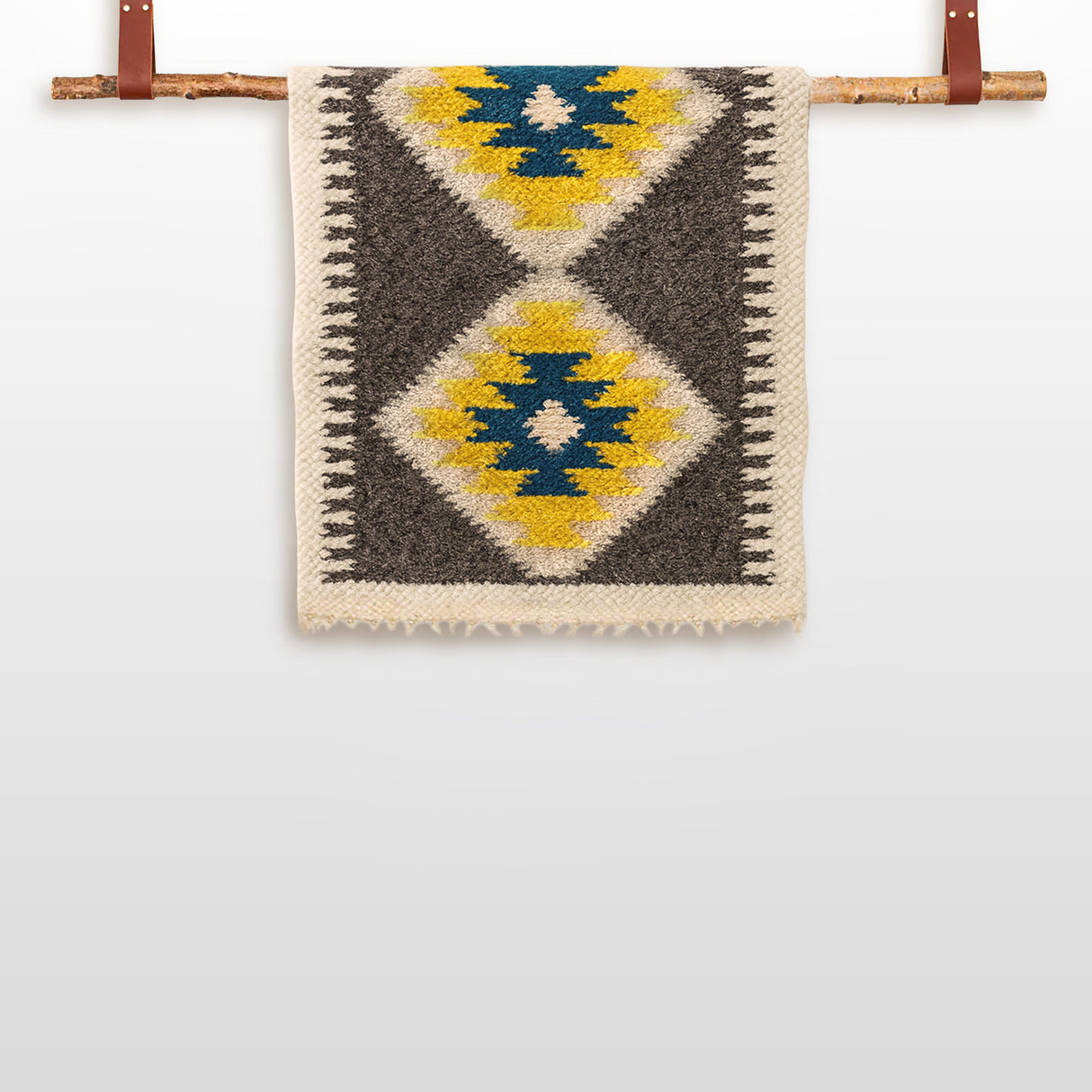 The Mriya (Dream) Wool Wall Hanging, featuring blue, yellow, and black diamond patterns, is handcrafted from Carpathian sheep wool and suspended on a wooden rod with leather straps.
