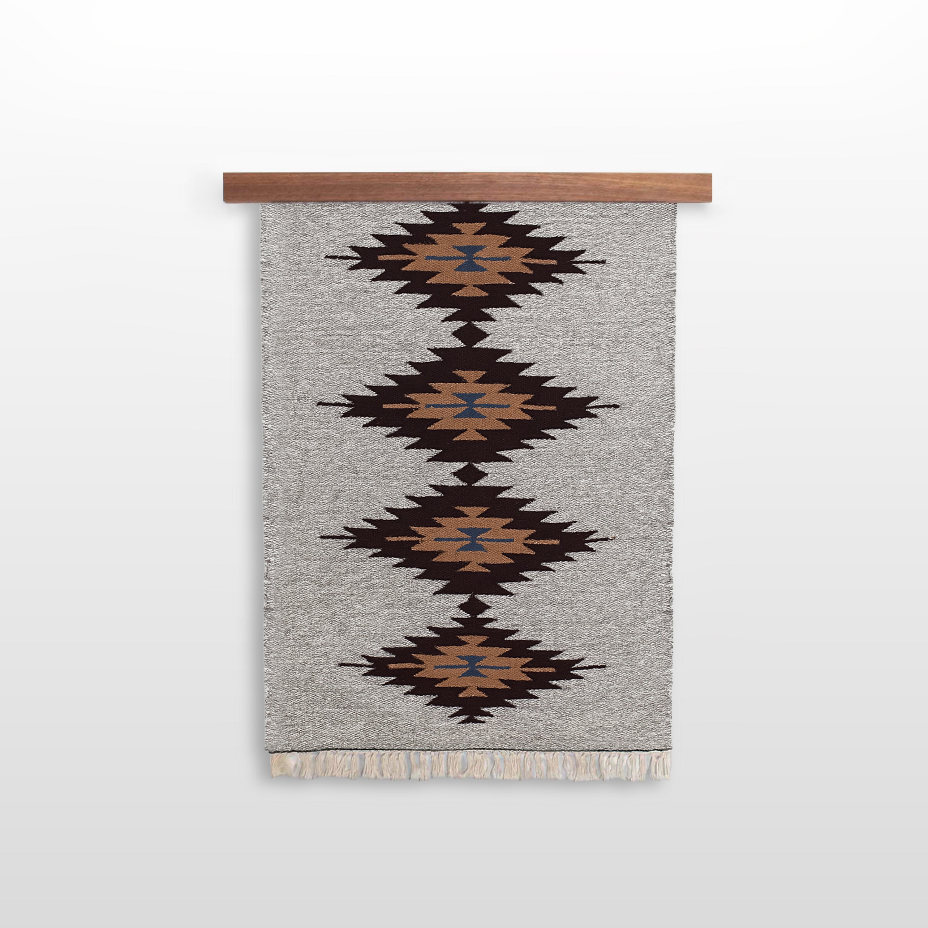 A gray woven rug with brown, black, and blue diamond patterns hangs on an African Sapele Wood Wall Hanging Rug Hanger, making striking, eco-friendly wall decor.