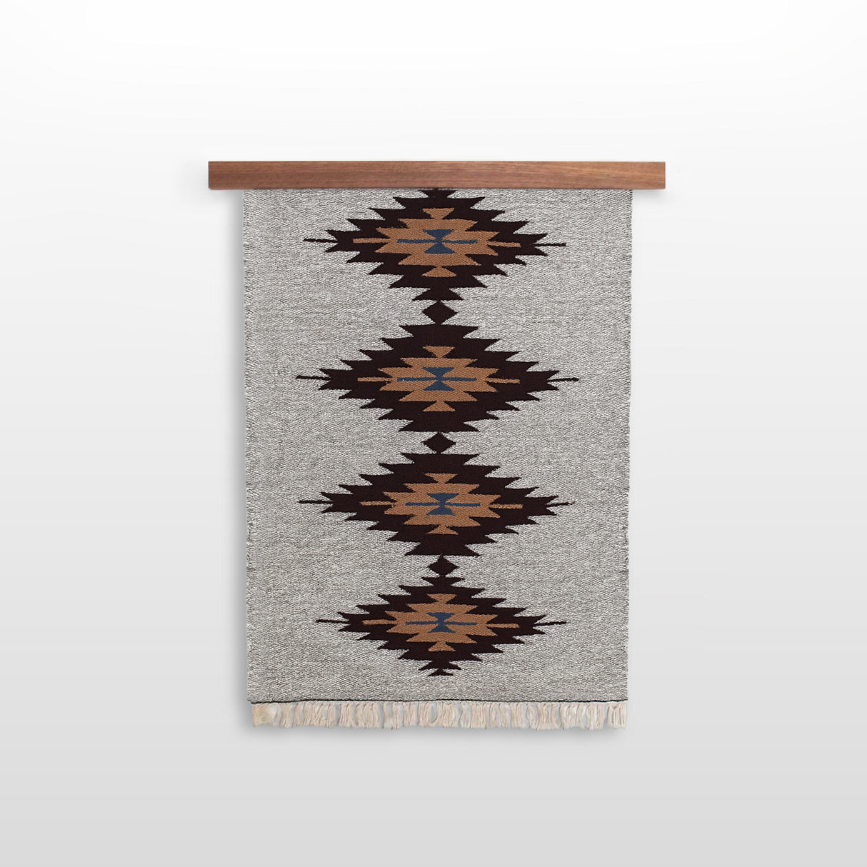 A gray woven rug with brown, black, and blue diamond patterns hangs on an African Sapele Wood Wall Hanging Rug Hanger, making striking, eco-friendly wall decor.