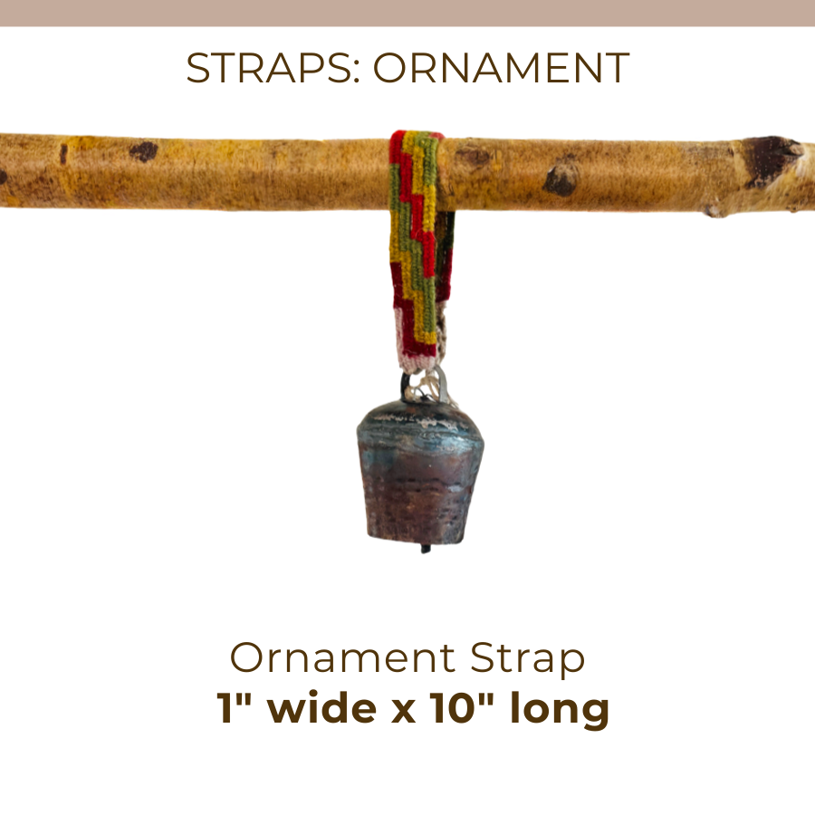 A vibrant, hand-woven “Ornament Straps for Hanging Vintage Bells” with a small metal bell (1 inch wide x 10 inches long) is suspended from a branch.