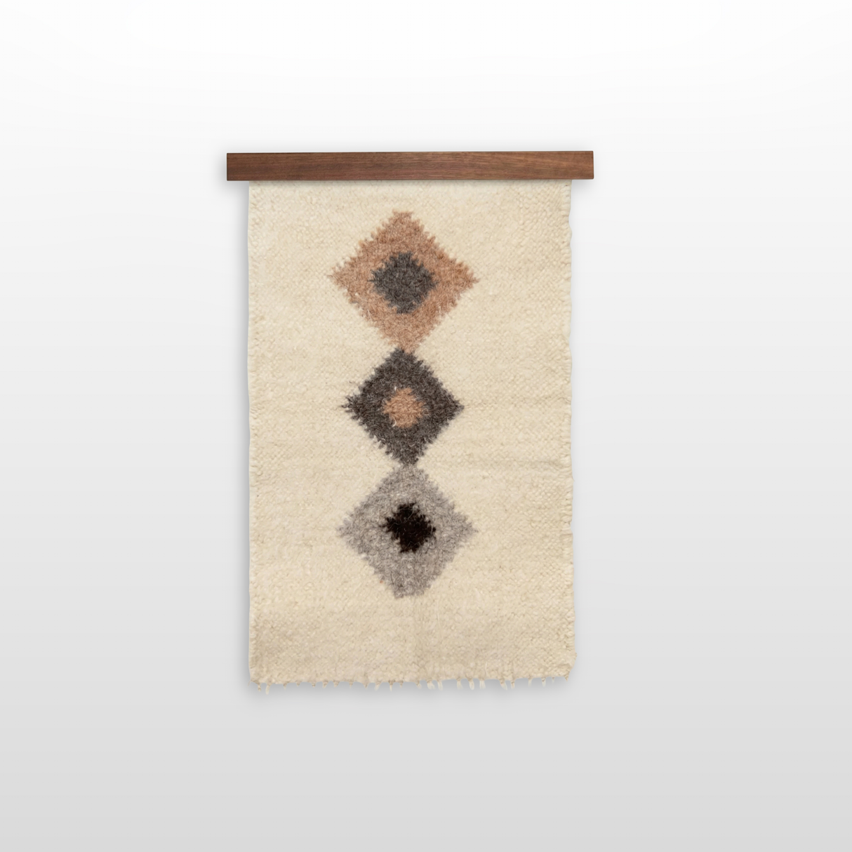 The Harny (Beautiful) Wool Framed Wall Art features three diamond shapes in brown, black, and gray on a beige background, crafted from Carpathian wool and mounted on handcrafted cedar for texture and warmth.