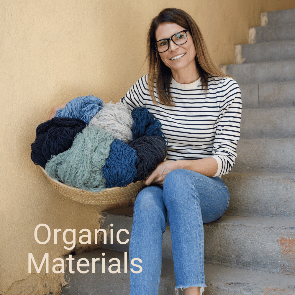 Woman in glasses sitting on stairs, holding a basket of colorful yarn with text