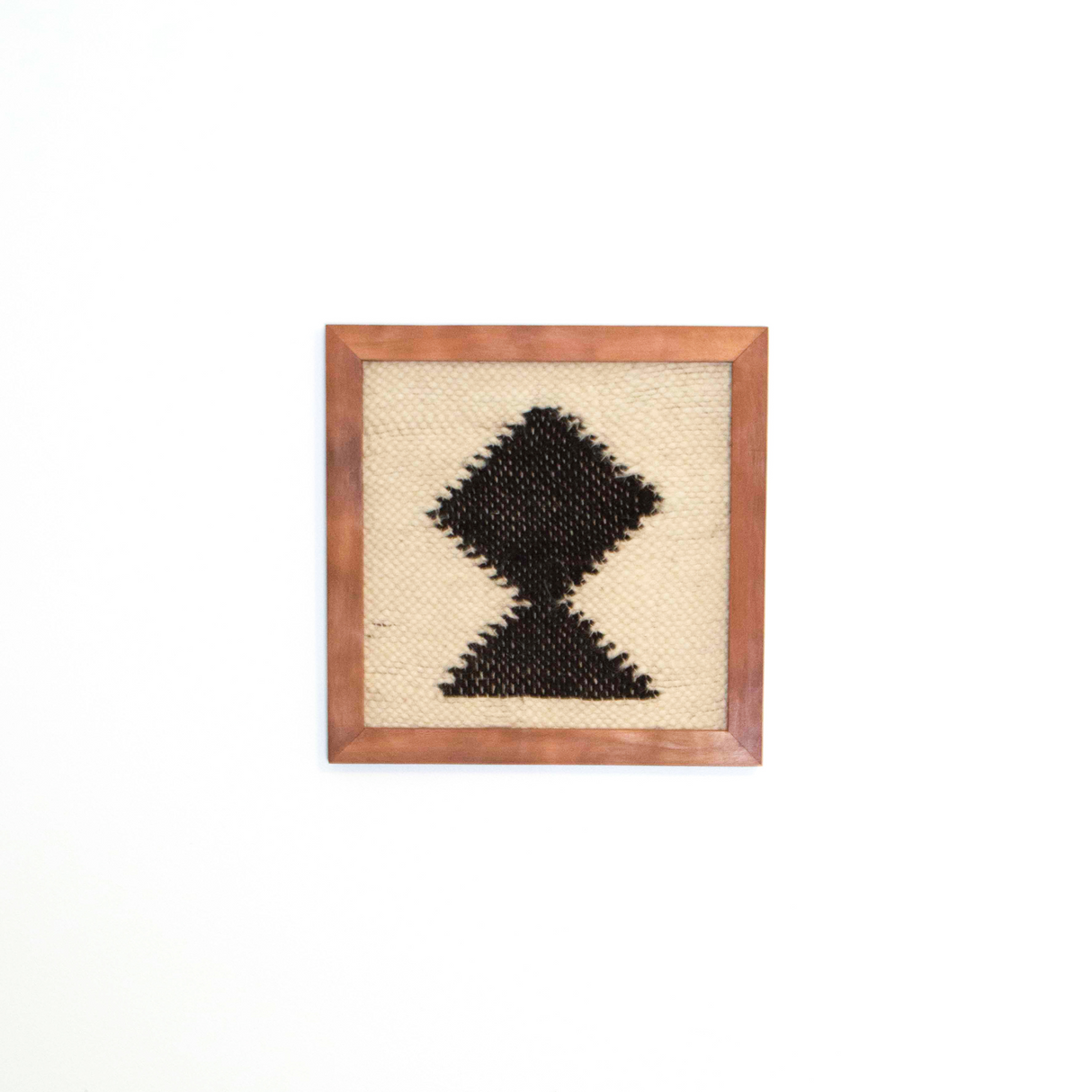 The Blysk (Shine) Wool Framed Wall Art features a black geometric diamond pattern on beige wool, framed and ready to hang—a minimalist wall art piece ideal for adding modern style to any clean, contemporary space.