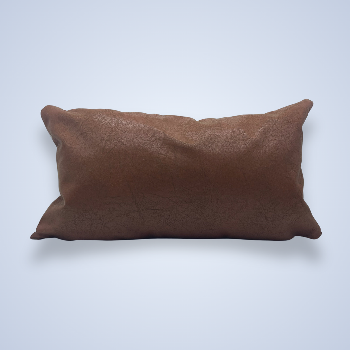 The Handwoven Blazheny (Blissful) Pillow in rectangular vegan leather brown lies on a light blue background.