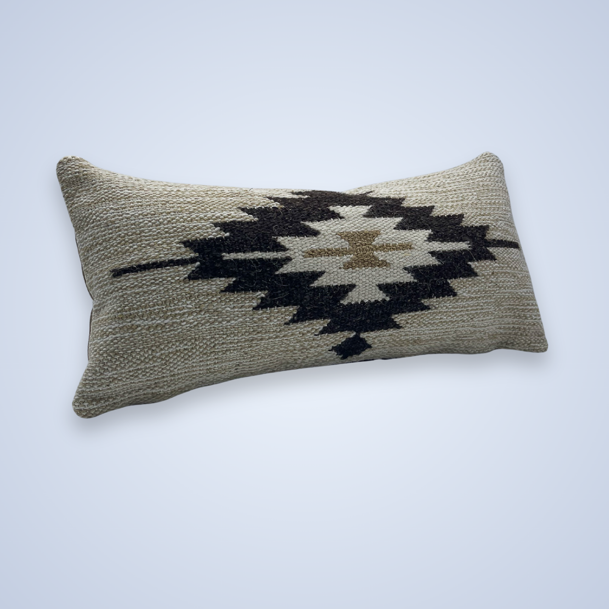 The Handwoven Chitki (Crisp) Pillow is a rectangular lumbar pillow with a woven beige cover and a bold black and brown geometric diamond pattern in the center.