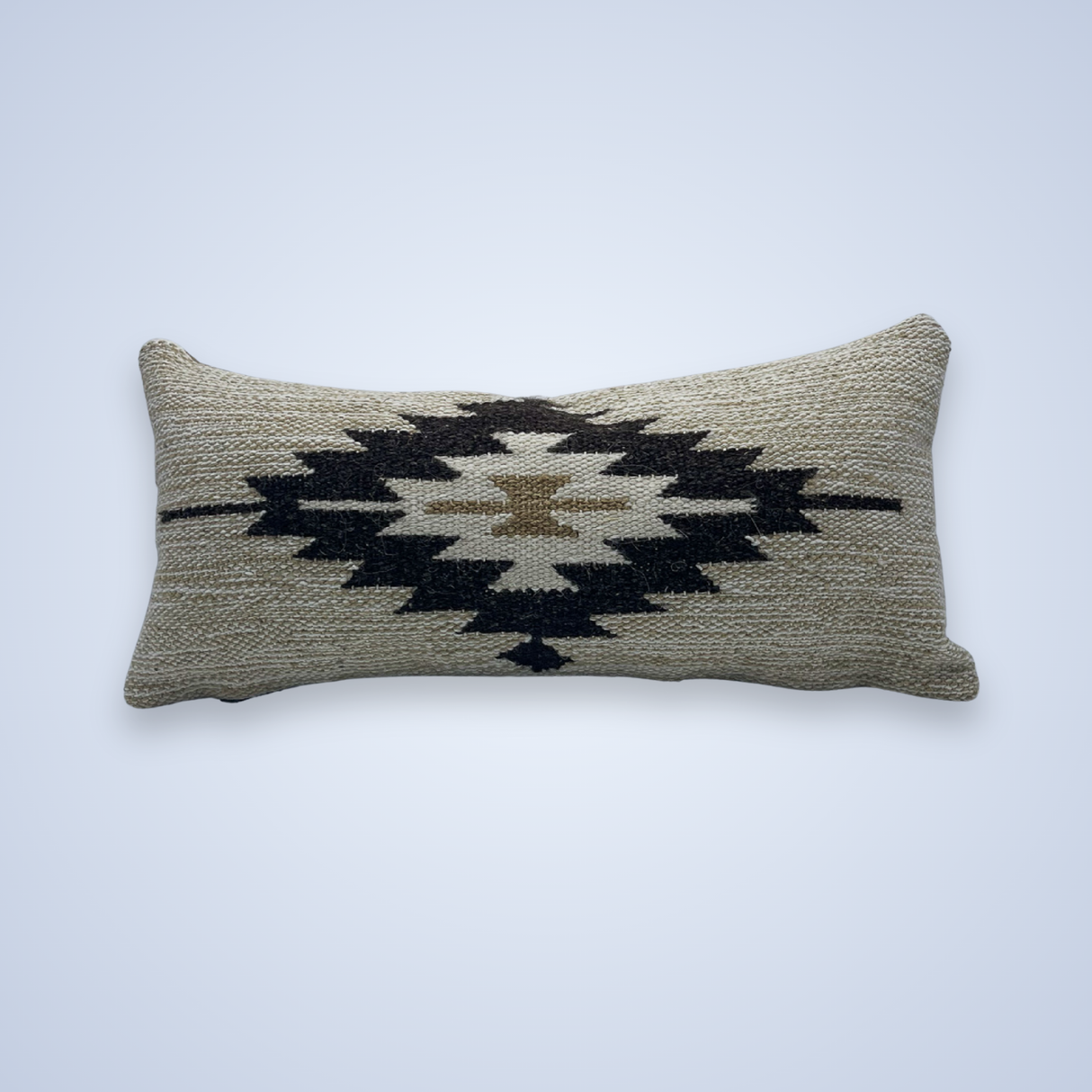 The Handwoven Chitki (Crisp) Pillow is a rectangular lumbar pillow with a woven black and tan geometric pattern on a beige background.