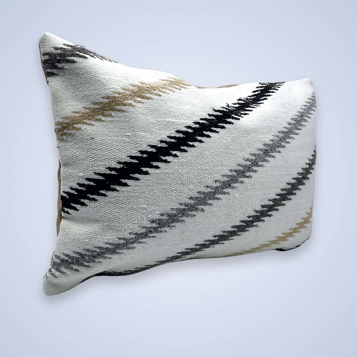 The Handwoven Promin (Beam) Wool Pillow features white fabric with black, gray, and beige zigzag stripes on a light background—ideal for adding modern style to your space.