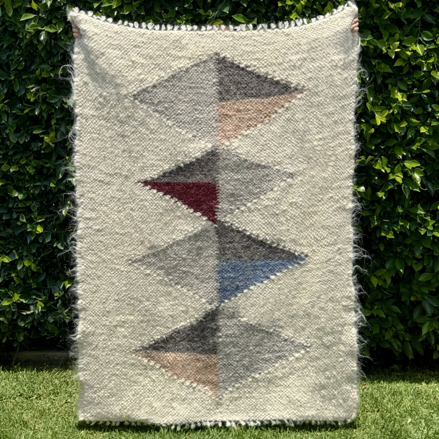 The Harmonia A (Harmony) Wool Statement Throw / Baby Blanket features handwoven, multicolored stacked diamonds and makes an artsy, charming accent—perfect for adding character to any space.