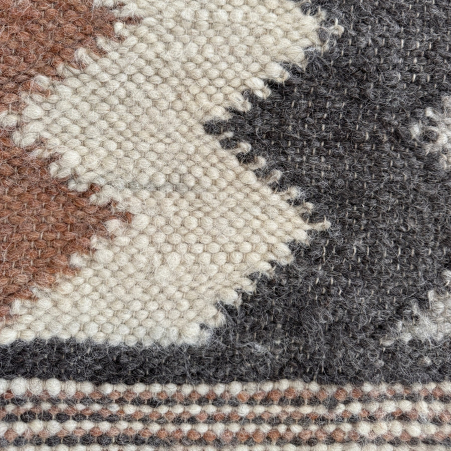 Close-up of the Myr (Peace) Wool Statement Throw / Baby Blanket, made from all-natural undyed yarn with a bold geometric pattern in brown, cream, and black—ideal as a unique statement blanket.