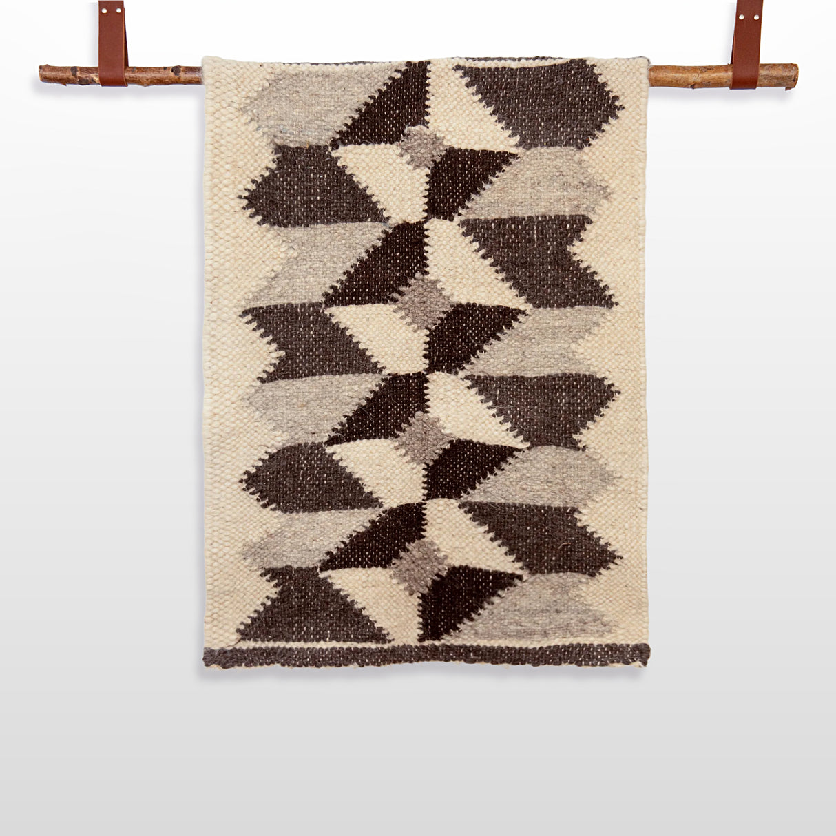 The Remeslo (Craft) Wool Wall Hanging features a geometric brown and beige Ukrainian design, displayed on a wooden rod with leather straps. Made from natural wool, it adds handcrafted charm to any space.