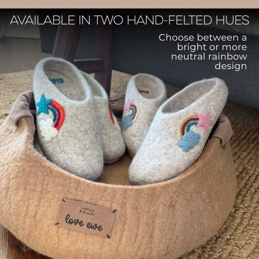 Two pairs of Love Ewe Hand-Felted Organic Wool Slippers for Women (Rainbow-Light) sit in a soft tan basket labeled "love ewe," each pair fair trade and lovingly handmade in Nepal.