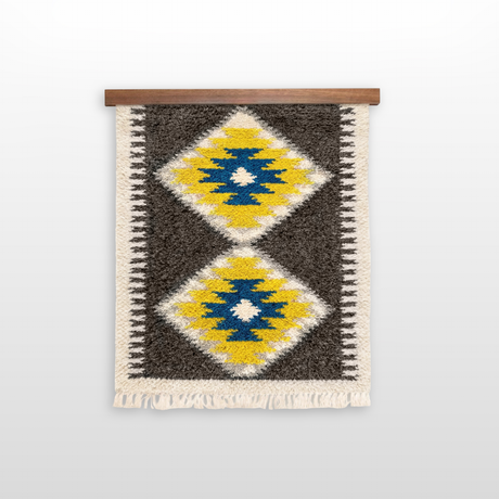 The Mriya (Dream) Wool Wall Hanging features two yellow and blue diamond patterns, handwoven in Carpathian tradition. Displayed on a wooden rod, it's ideal for stylish and sustainable home decor.