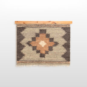 The Myr (Peace) Wool Wall Hanging features a geometric pattern crafted from all-natural undyed yarn on a wooden rod, with earthy tones inspired by Ukrainian tradition, shown against a white background.