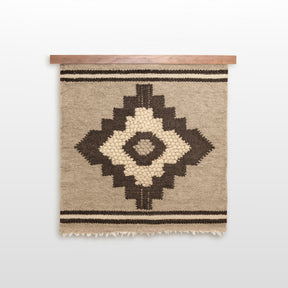 The Karaliene (Queen) Wool Wall Hanging features handcrafted beige wool with a central black rhombus-dot motif and two bold horizontal black stripes.