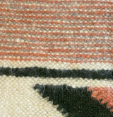 Close-up of a Handmade Organic 100% Sheep Wool Woven Statement Blanket, featuring geometric patterns in cream, pink, black, and reddish tones—an eco-friendly bed covering that highlights sustainable craftsmanship.