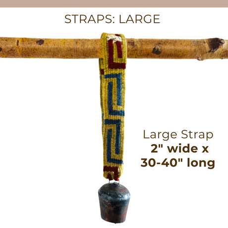 A vibrant, handcrafted Large Strap for Hanging Vintage Bells (2'' wide x 30-40'' long) hangs from a branch, supporting a metal bell.