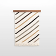 The Promin (Beam) Wool Rug / Wall Hanging, featuring diagonal brown, tan, and black stripes with fringe, comes with a Wood Rug Hanger ($240 value)—a distinctive gallery wall art piece for your space.
