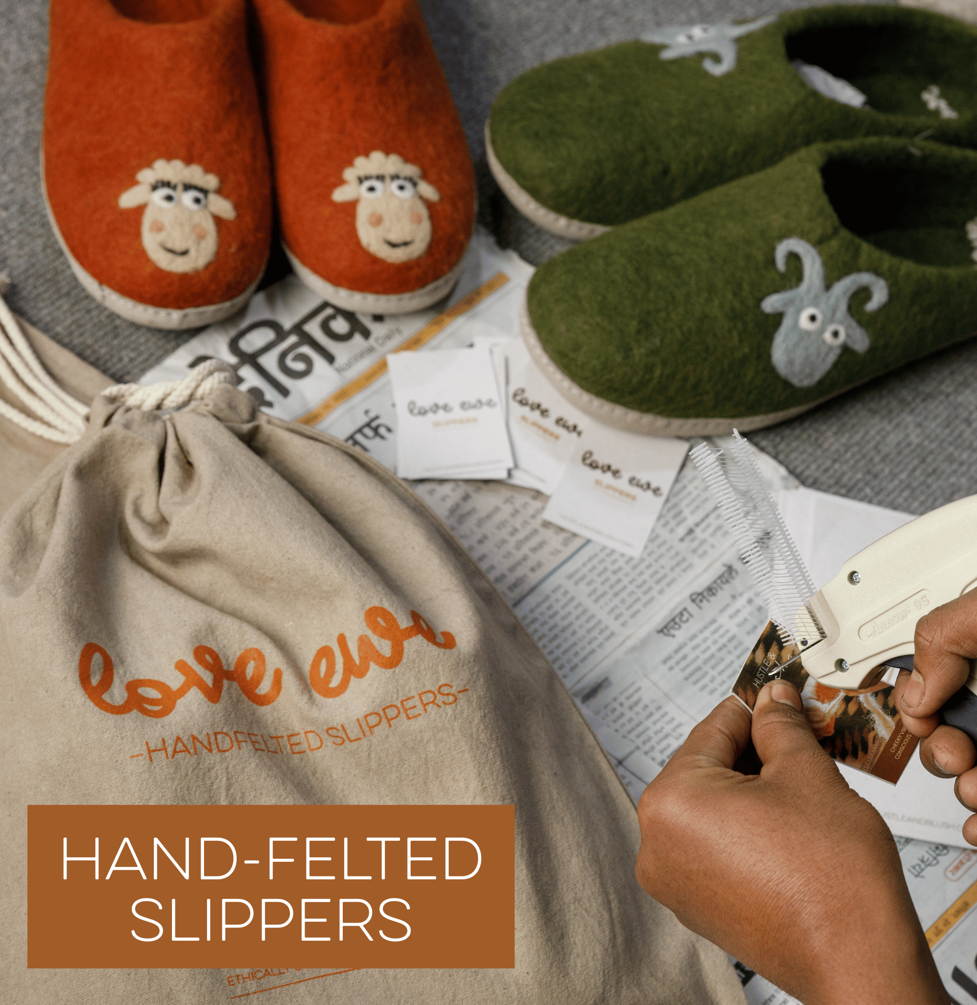 Orange and green wool slippers with animal faces, a cloth bag, tags, and hands using a tagging gun.