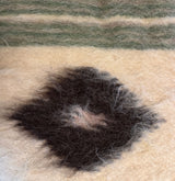 Handmade in Ukraine, this organic 100% sheep wool blanket features a black diamond pattern with green and beige stripes—a unique Carpathian wool bed covering and statement bedspread.