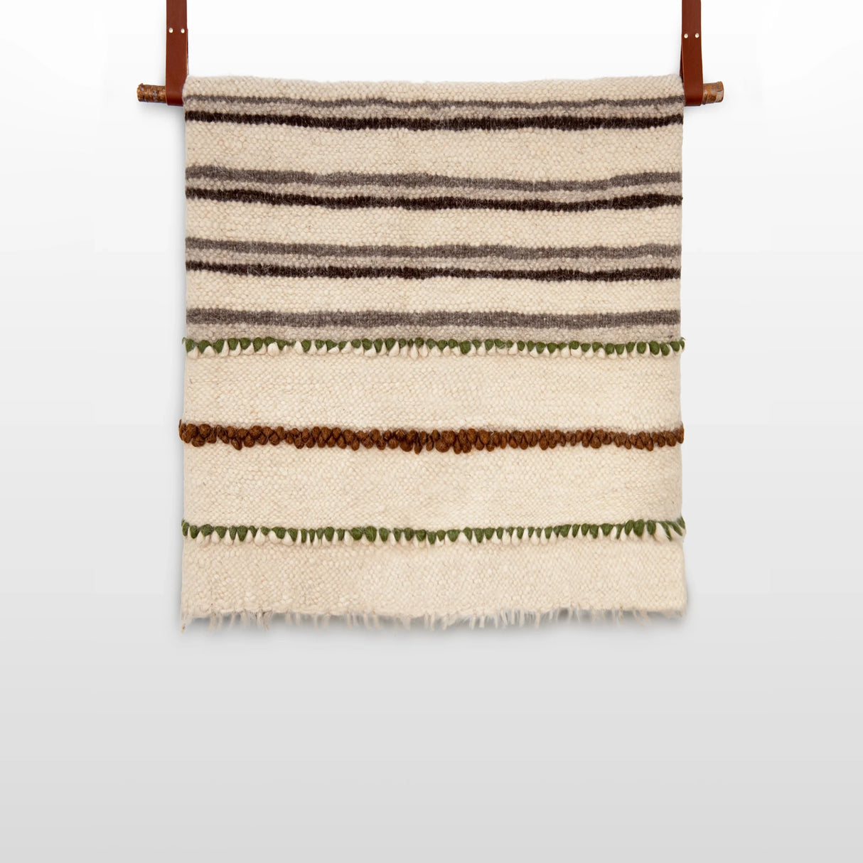 The Faino (Fine) Wool Statement Bed Blanket features horizontal stripes in brown, green, and cream, crafted to resemble a handwoven textile and accented with two leather straps for hanging.