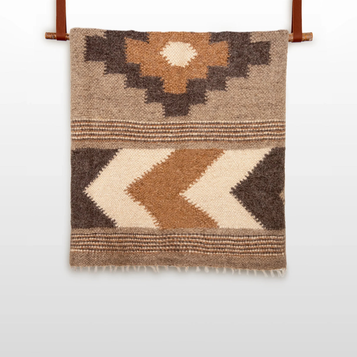 The Myr (Peace) Wool Statement Bed Blanket features geometric patterns in brown, beige, and cream on a white background, crafted from organic wool for a cozy, natural touch.