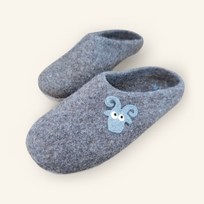 Love Ewe Hand-Felted Organic Wool Slippers for Men (Blu-B) are gray handmade Nepal slippers crafted from soft wool, featuring a charming blue sheep face on the front.