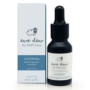 A 0.5oz dropper bottle and box of Ewe Dew by Fluff Ewes Cottontail Home Fragrance + Aromatherapy Essential Oil Blend (Clean & Crisp), ideal for wool dryer balls or diffuser, as a natural fabric freshener.