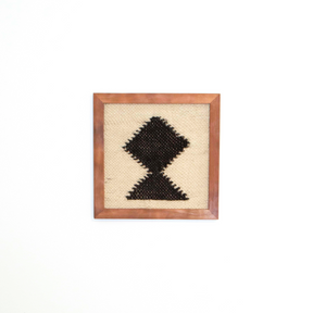 The Blysk (Shine) Wool Framed Wall Art features a black geometric diamond pattern on beige wool, framed and ready to hang—a minimalist wall art piece ideal for adding modern style to any clean, contemporary space.