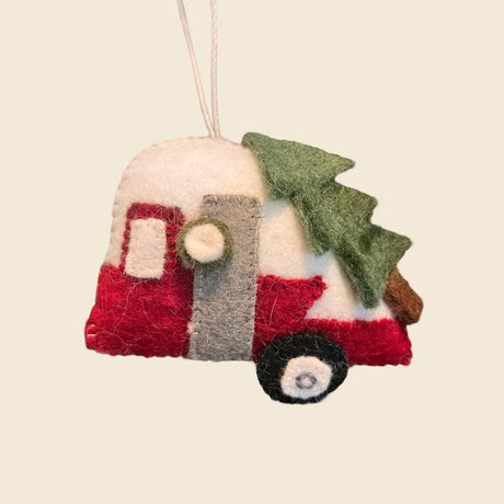 Camper with Christmas Tree is a charming wool ornament featuring a red camper with a green tree on top, hung by a string—perfect for fans of artisan holiday decor and unique Christmas ornaments.