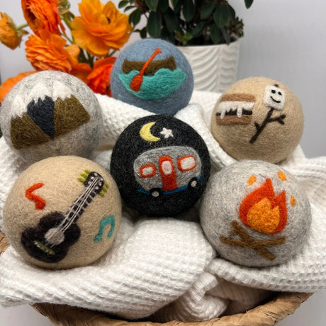 Fluff Ewes "Are we there yet?" Premium Wool Dryer Balls—6 eco-friendly New Zealand wool balls featuring camping-themed designs like a campfire, guitar, and camper. Perfect natural fabric softener for a greener laundry routine.