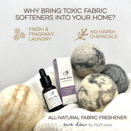 Ewe Dew by Fluff Ewes Lavender Rain Laundry, Home Fragrance + Aromatherapy Essential Oil Blend (Lavender Citrus Scent), shown with dryer balls and packaging on a towel. For use with wool dryer balls or diffuser. No harsh chemicals. 0.5 fl oz/15mL.