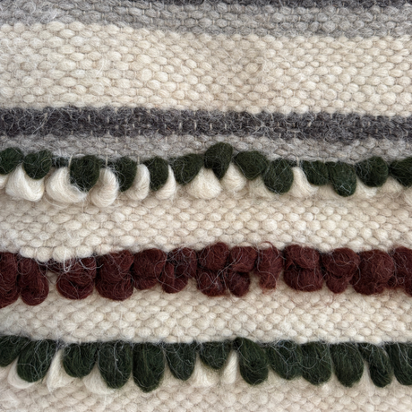 Close-up of the Faino (Fine) Wool Statement Throw/Baby Blanket, showcasing handcrafted cream, green, maroon, and gray textured stripes and looped details.