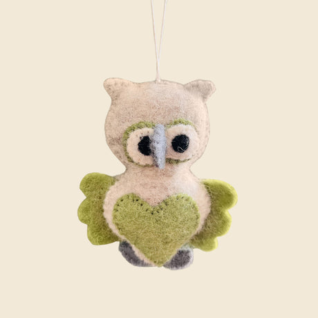 Hand-Stitched Felted Owl Ornament with green wings and a heart-shaped belly, hanging on a string. This whimsical wool ornament brightens up any artisan Christmas ornaments collection.