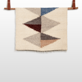 The Harmonia A (Harmony) Wool Statement Throw / Baby Blanket features geometric diamond patterns in blue, gray, brown, and beige—an artsy accent that adds cozy modern charm to your decor.