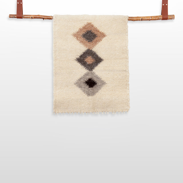 The Harny (Beautiful) Wool Framed Wall Art features three diamond designs on woven fabric, displayed on a handcrafted cedar frame with leather straps—ideal as nursery décor or stylish wall art.