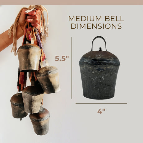 A hand holds five vintage handmade Pahāḍa yak, goat & sheep’s bells from the Himalayan Mountains of Nepal and Tibet; one fair trade 5" bell is perfect for Christmas ornaments, wreath decor, or sound baths.
