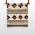 The "Handmade in Ukraine, Organic Natural 100% Sheep Wool Woven Statement Blanket Bed Covering Bedspread Duvet" features brown and green stripes with diamond patterns and hangs elegantly on a wooden rod.