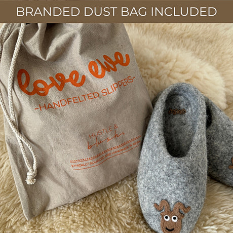 Love Ewe Hand-Felted Organic Wool Slippers for Men (Beau-G), grey with a charming animal design, are shown beside a branded dust bag labeled "love ewe – Handfelted Slippers.