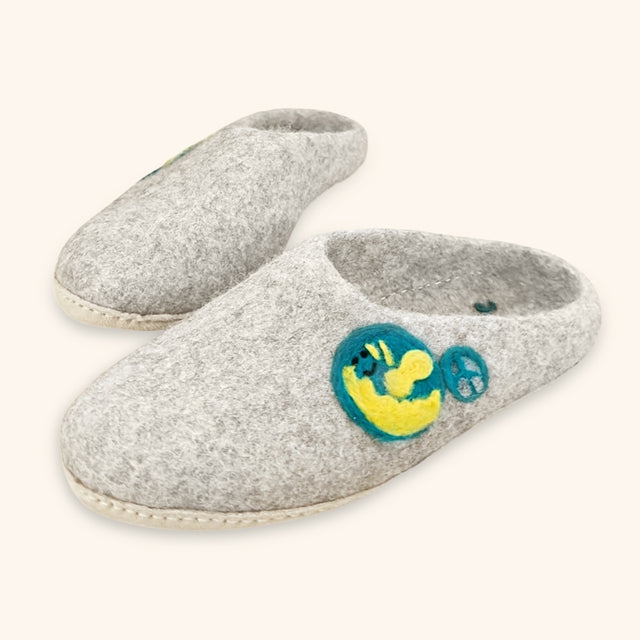 Love Ewe Hand-Felted Organic Wool Slippers for Men (Peace-LG) feature sustainable grey felt, hand-sewn suede soles, and yellow and blue embroidered smiley face with peace sign for comfort and unique style.