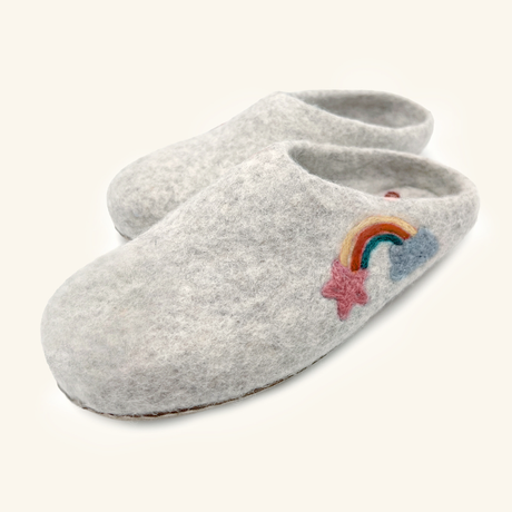 Love Ewe Hand-Felted Organic Wool Slippers for Women (Rainbow-Light) have hand-sewn soles and feature a rainbow, blue cloud, and pink star embroidered on the gray felt top.