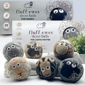 Six Fluff Ewes Natural Wool Dryer Balls (3 for Darks, 3 for Lights/Whites) are displayed on towels before two Fluff Ewes box bundles ($58 value), highlighting their eco-friendly appeal.