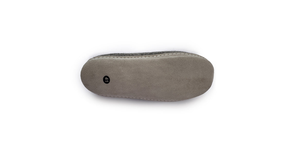 Gray suede sole with visible stitching shown from below on a white background. Love Ewe Hand-Felted Organic Wool Slippers for Men (Blu-B) are handmade in Nepal, showcasing excellent craftsmanship and detail.