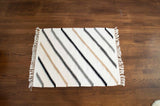The Handmade in Ukraine Organic Natural 100% Sheep Wool Woven Rug features diagonal black, beige, and gray zigzag stripes—ideal for eco-friendly decor as a small rug or wall hanging.
