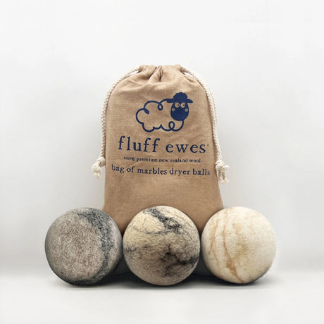 Three Fluff Ewes "Bag of Marbles" Premium Dryer Balls, made from 100% natural dye-free marbleized sheep's wool, are displayed in front of a drawstring bag—an eco-friendly laundry essential. Set of 3.