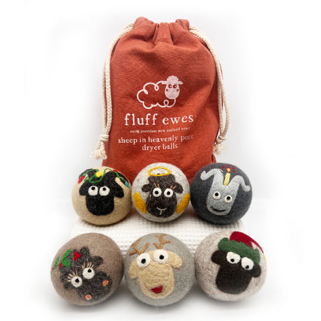 Fluff Ewes Premium XL Dryer Balls: "Sheep in Heavenly Peace" 6 Pack—holiday limited edition, featuring six cute sheep wool balls in front of a red drawstring bag—an eco-friendly, natural fabric softener alternative.